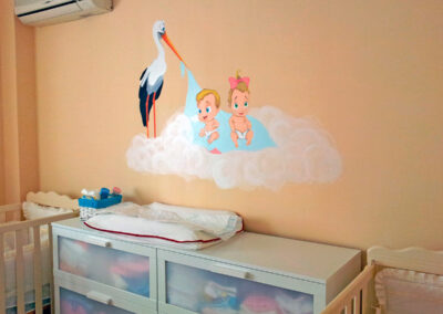 Pintura mural en habitación infantil Cigueña y bebés mellizos